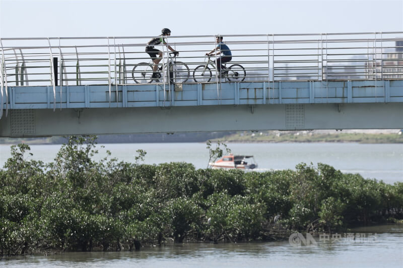 圖為北市關渡騎自行車民眾。（中央社檔案照片）