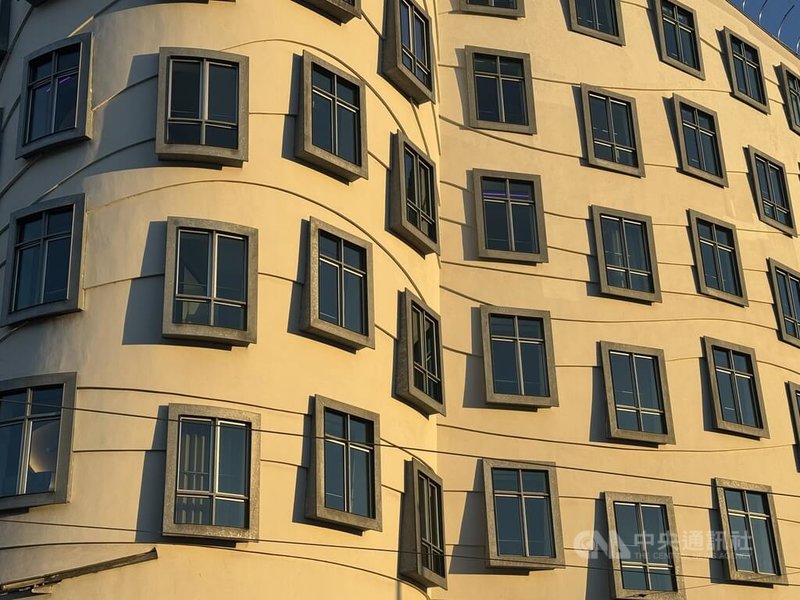 布拉格著名地標「跳舞的房子」沿著河岸的建築立面上,外凸邊框的窗戶如同一幅幅畫框,營造立體感;其外牆蜿蜒起伏的線條模糊透視效果,降低與周圍傳統建築的衝突。中央社記者劉郁葶布拉格攝 114年12月7日