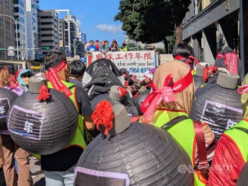 台灣移工聯盟等團體7日舉辦移工大遊行，訴求「廢除藍領移工工作年限」，遊行隊伍前排，多名移工身後背著大型紙製的假炸彈，並將假炸彈上的年限塗黑，表達希望「炸開年限」的訴求。中央社記者張雄風攝　114年12月7日