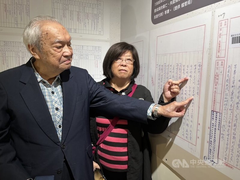 台北市二二八協會榮譽理事長黃秀婉（右）說，知道拂塵專案的人不多，並與同為受害者家屬徐世雄（左）一起在寫有自己受害長者姓名的文件前合影為證。中央社記者楊淑閔攝 114年12月8日