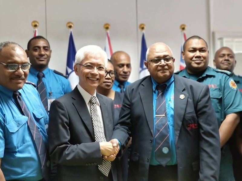 駐斐濟代表周進發（前排中間）代表台灣內政部消防署，將一批急救物資移交給斐濟國家消防局，展現台灣支持斐濟強化救災及急救能力的承諾；斐濟消防局長 Puamau Sowane（前排右）指出，該批物資將直接提升斐濟的院前緊急救護能力。（駐斐濟代表處提供）中央社記者丘德真雪梨傳真　114年12月9日