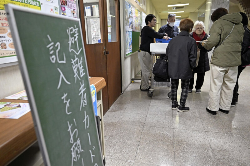 日本青森縣東方外海8日晚間11時15分發生規模7.5地震，民眾在嚴寒天氣中趕往日高町避難所。（共同社）