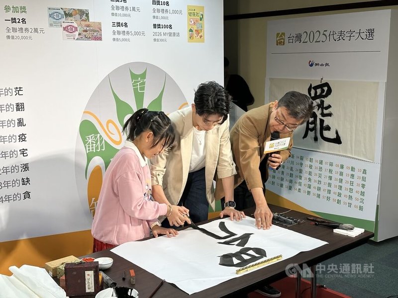 台灣女子拳擊好手林郁婷(中),在小小書法家蔡婷而(左)的指導下,一起揮毫寫下台灣2025代表字「罷」。中央社記者黎建忠攝 114年12月10日