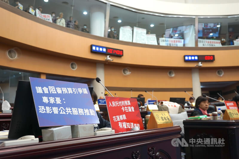 花蓮縣議會11日進行臨時會一讀會,審議縣府22項提案,光復災民到2樓旁聽,國民黨籍議員在桌面放上「人民託付的預算卡在議會,花蓮鄉親有權知道原因」看板。中央社記者張祈攝 114年12月11日