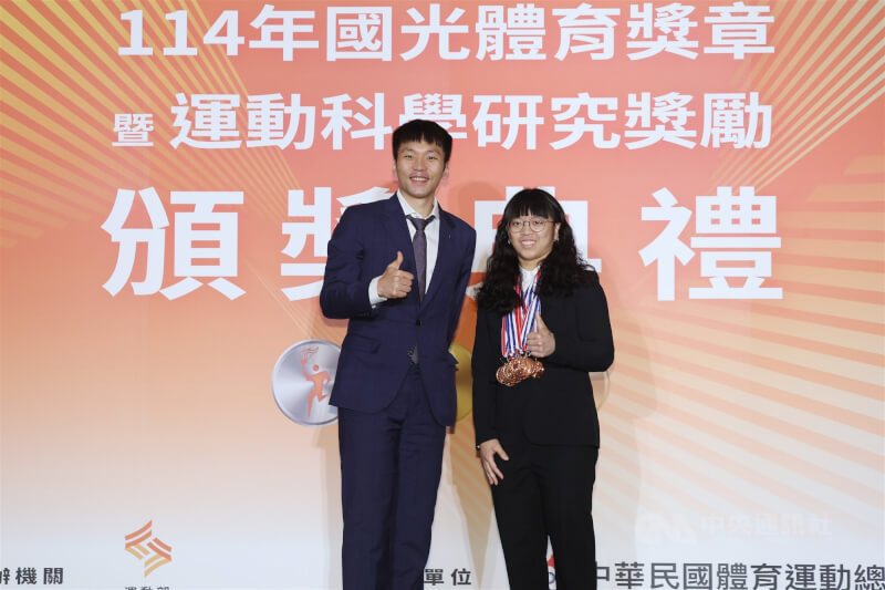 舉重女將陳冠伶（右）在多個國際賽事表現亮眼，11日於114年國光體育獎章暨運動科學研究獎勵頒獎典禮中，由運動部長李洋（左）頒發12面國光獎章。中央社記者張新偉攝　114年12月11日
