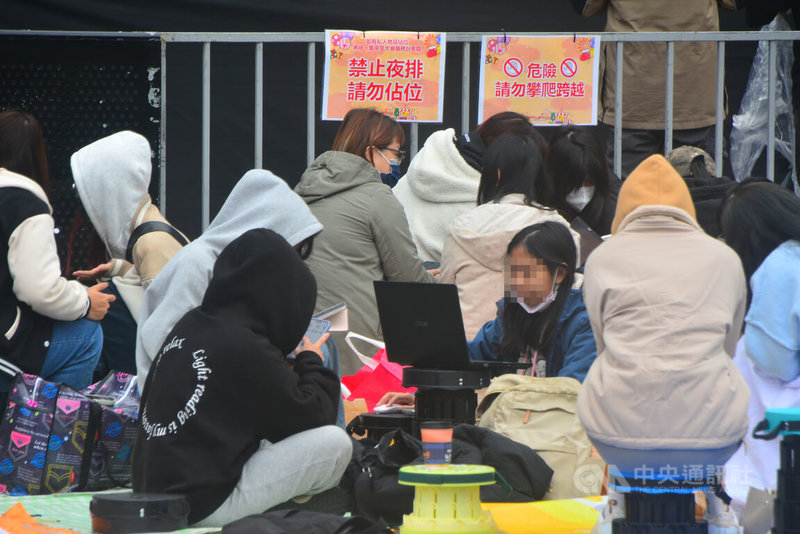 2025新北歡樂耶誕城13日重頭戲巨星耶誕演唱會，大批民眾無懼氣溫持續下滑，12日下午提前冒雨在活動舞台前席地而坐卡位。中央社記者黃旭昇新北市攝　114年12月12日