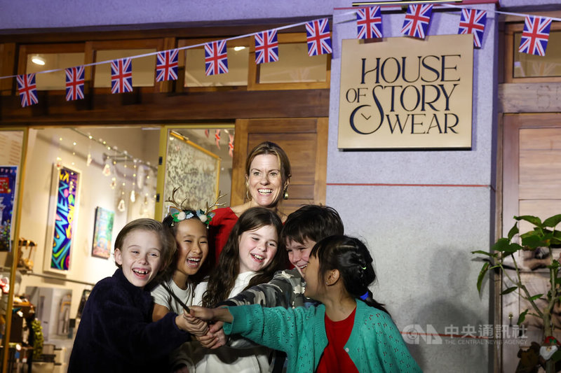 首屆「英倫聖誕嘉年華」活動12日在台北大稻埕永續百貨（House of Story Wear）舉行點燈儀式，英國駐台代表包瓊郁（Ruth Bradley-Jones）（後中）出席，與孩子們在歡笑聲中一同點亮燈飾。中央社記者王騰毅攝  114年12月12日
