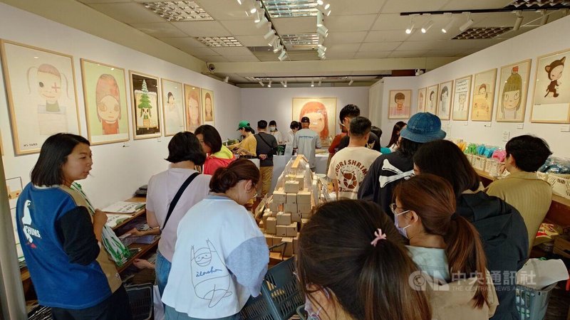 中華文化總會主辦的日本當代藝術家奈良美智在台10年巡展第5站前進嘉義縣，12日在新港文化館開展，展場周邊設周邊商品販售點，擠滿購買人潮。中央社記者蔡智明攝　114年12月12日