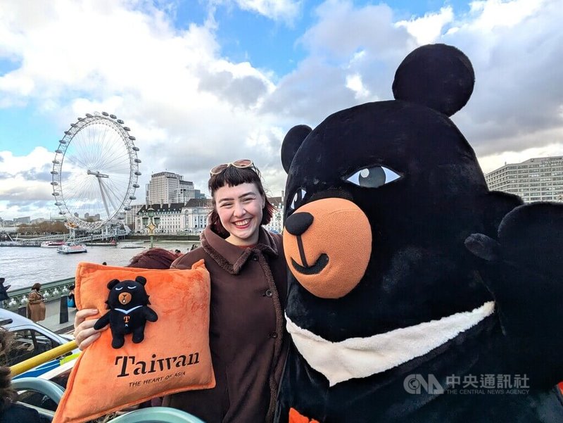 英國插畫家漢娜（左）為台灣設計的觀光巴士全車身廣告12月在倫敦上路，她10日與觀光署吉祥物「喔熊」一同乘車體驗。漢娜告訴中央社，希望透過廣告設計傳達台灣的溫暖。中央社記者陳韻聿倫敦攝　114年12月13日