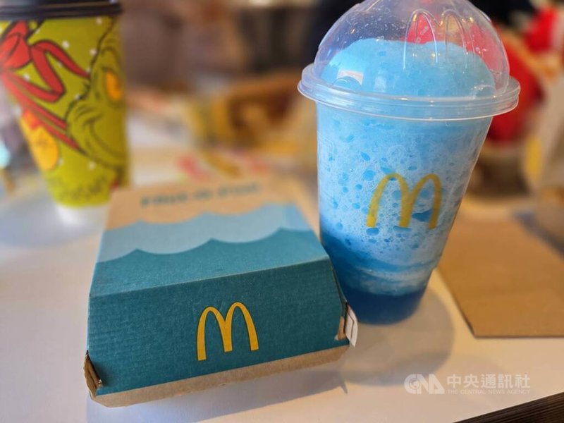 店內販售的商品和全球麥當勞大同小異，不少旅客會手拿該店限定的藍色冰沙、以招牌為背景拍照。中央社記者江明晏攝 114年12月13日