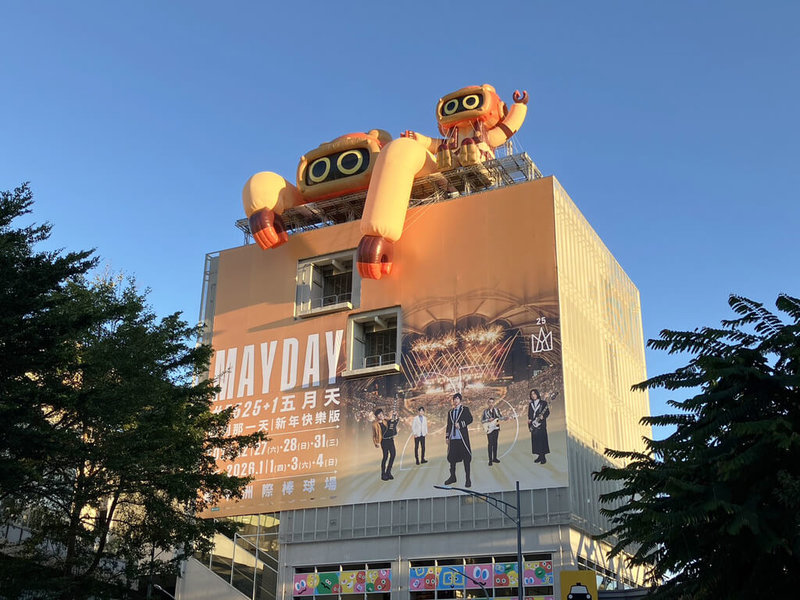 五月天樂團今年底將在台中開唱，台中捷運規劃行銷活動，綠線松竹站外牆換上巨幅五月天演唱會主視覺帆布，窗貼則以象徵五名團員的五色表情球打造繽紛氛圍，吉祥物「菜頭粿」更裝飾在車站頂樓，相當吸睛。（台中捷運提供）中央社記者蘇木春傳真　114年12月14日