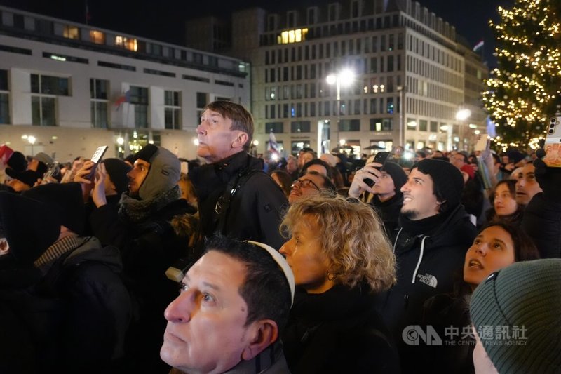 柏林布蘭登堡光明節點燈儀式有超過20年歷史,燭台高達10公尺,民眾仰頭望向第一道正被點燃的「光明燈」。中央社記者林尚縈柏林攝 114年12月15日