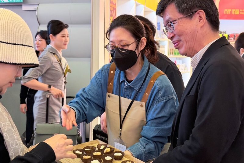 農糧署16日於桃園國際機場啟動「米糧精品伴手禮」展售專區,精選多款具台灣特色米製精品伴手禮進駐機場,副署長黃昭興(右1)也與銷售人員一起招待民眾試吃。(農糧署提供)中央社記者吳睿騏桃園機場傳真 114年12月16日
