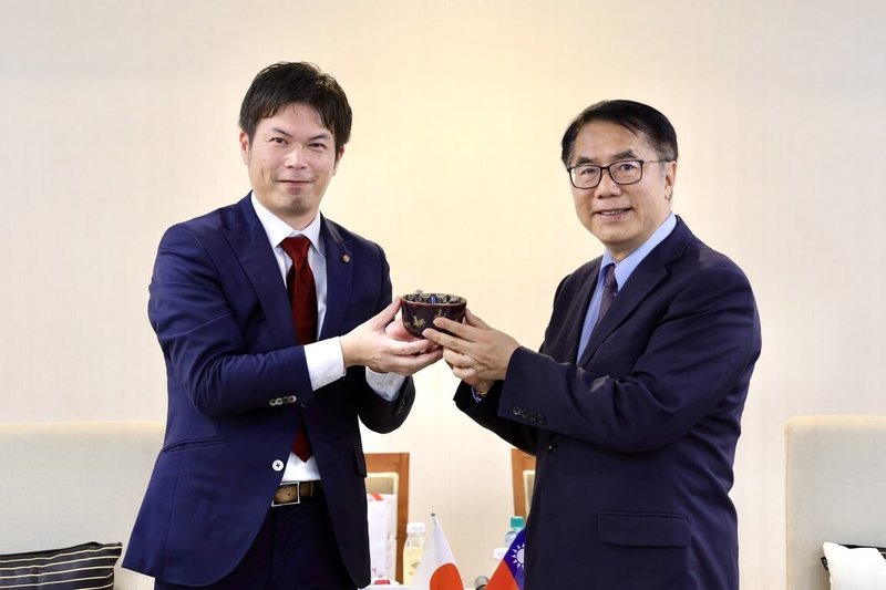 日本京都市議會運營委員會副委員長、市議員久保田正紀（左）16日拜會台南市長黃偉哲（右），致贈紀念品，並討論未來兩市教育、物產、體育等方面交流。（台南市政府提供）中央社記者張榮祥台南傳真　114年12月16日