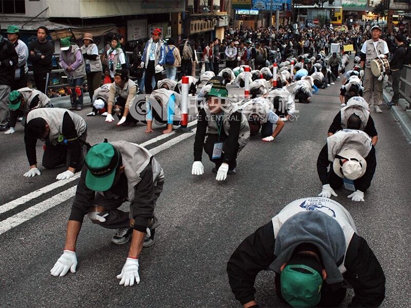 世界貿易組織（WTO）第六次部長級會議在香港召開，南韓農民以三步一叩拜的方式遊行，表達對WTO的不滿。中央社記者盧健輝攝 94年12月15日