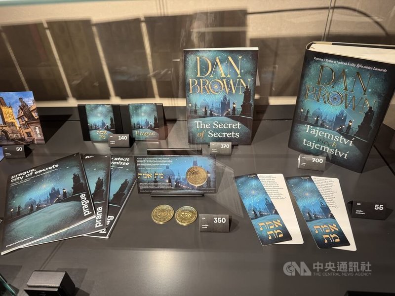 國際暢銷作家丹布朗的最新作品The Secret of Secrets以捷克首都布拉格為故事舞台，引起全球書迷對布拉格的關注。業者也順勢推出此書的周邊商品，如筆記本、明信片、書籤與紀念幣等。中央社記者劉郁葶布拉格攝　114年12月17日