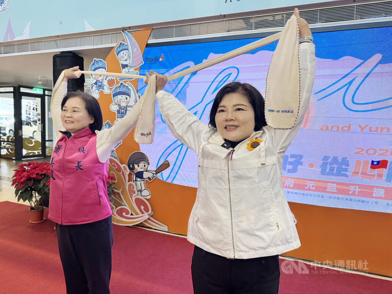 雲林縣行政處17日舉辦115年雲林縣元旦升旗宣傳記者會，雲林縣長張麗善（右）和北港鎮長蕭美文（左）展示活動紀念品「紗布運動巾」，邀請民眾屆時到北辰國小同歡。中央社記者姜宜菁攝　114年12月17日