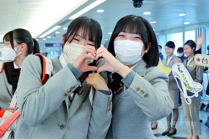 有「橘色惡魔」之稱的日本京都橘高校吹奏樂部團員18日搭機抵台，入境時，學生們相當開心，頻向接機人士揮手、比愛心。中央社記者吳睿騏桃園機場攝　114年12月18日