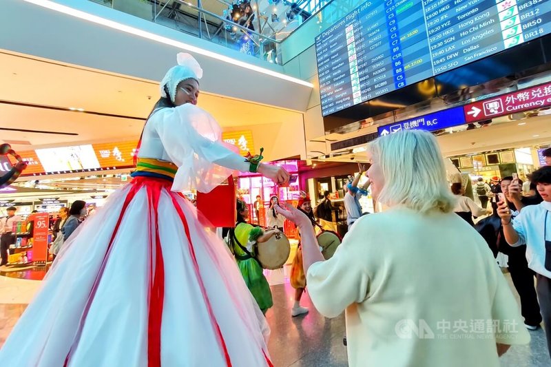 迎接耶誕節,桃園國際機場免稅店業者在桃機打造7公尺高台味互動耶誕樹,18日更邀表演團隊在航廈遊行演出,讓旅客感受台灣機場節日溫馨。中央社記者吳睿騏桃園機場攝 114年12月18日