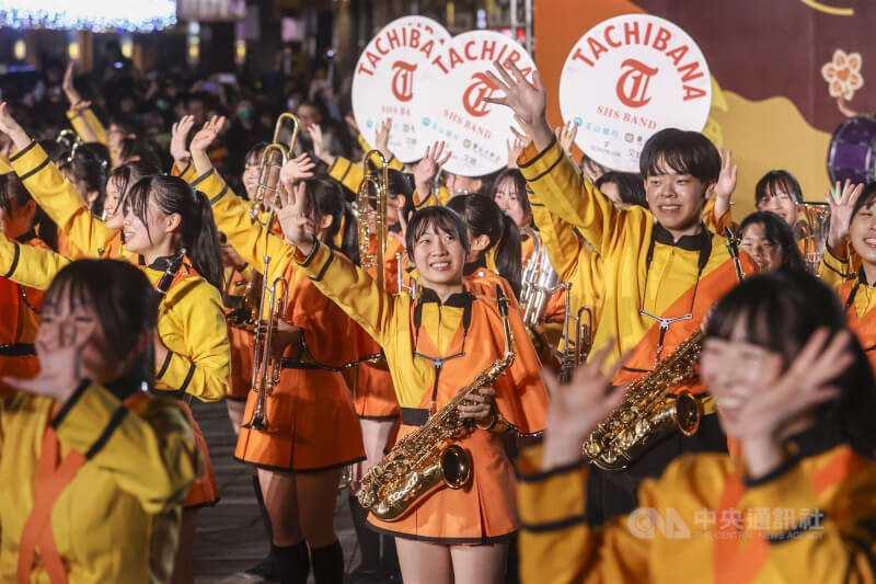 中華文化總會舉辦「2025台灣遠征–吹響友誼,舞動青春」系列活動,18日晚間邀請「橘色惡魔」日本京都橘高校吹奏樂部至台北中山堂廣場演出,成員們微笑揮手向現場熱情粉絲致意。中央社記者鄭清元攝 114年12月18日