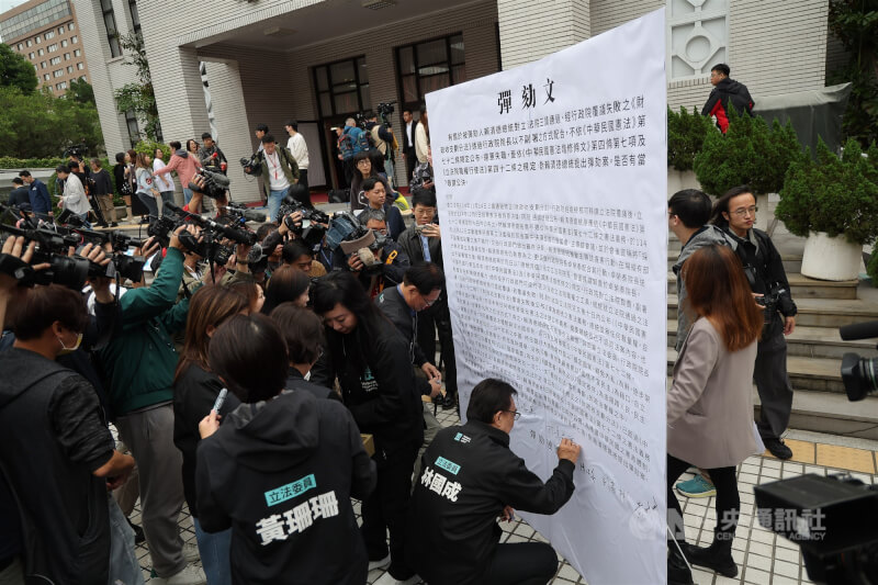 國民黨立法院黨團、民眾黨立法院黨團19日上午在立法院議場前共同舉行「彈劾違憲總統，反帝制、反專制、反獨裁」聯合記者會，現場擺放彈劾文大字報供立委簽名連署。中央社記者翁睿坤攝　114年12月19日