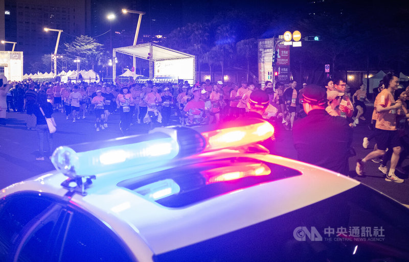 台北車站與台北捷運中山站19日晚間發生嫌犯張文投擲煙霧彈及傷人事件，台北市政府強調，相關賽事將照常舉行，但已全面升高維安等級。圖為2025台北馬拉松「耶誕歡樂早餐跑」20日清晨舉行，現場周圍有警力維護現場秩序與安全。中央社記者趙世勳攝 114年12月20日