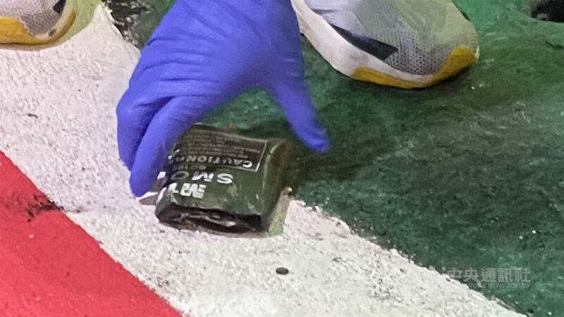 警方於捷運出口外馬路發現有疑似凶嫌使用的爆裂物殘骸，拍照蒐證後帶回調查。中央社記者黃旭昇台北攝  114年12月19日