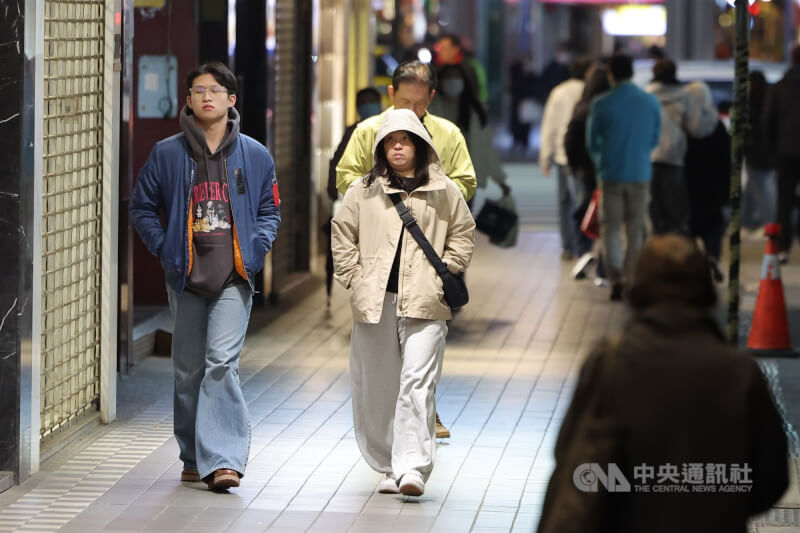 氣象署表示，21日東北季風增強，北部及東北部天氣轉涼，台北市低溫17、18度。圖為台北市大安區民眾穿上連帽衣物保暖。（中央社檔案照片）