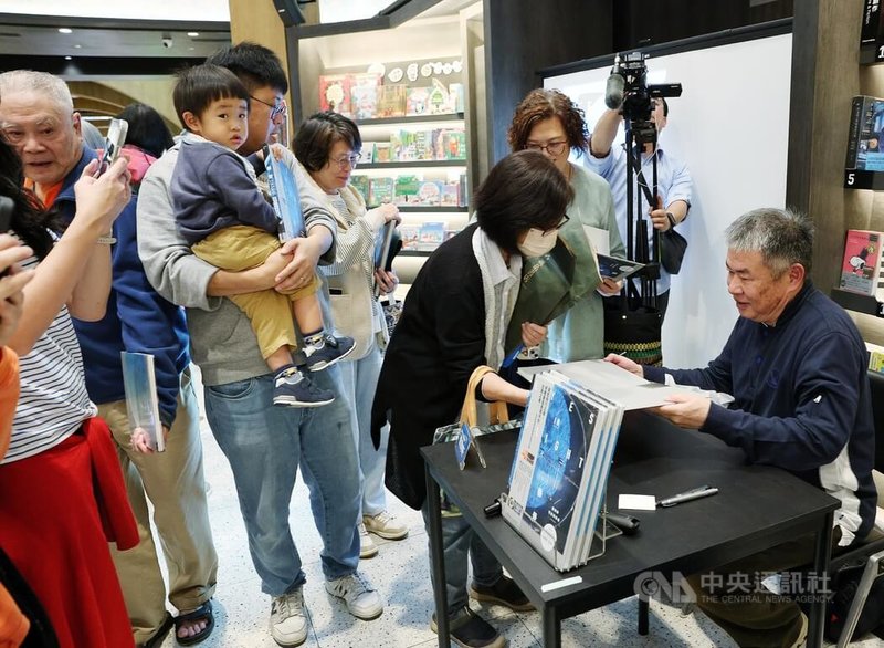 資深攝影工作者葉陶軒（右）21日下午在新北市新店區舉辦個人首本空拍攝影集「垂景」新書分享會，為讀者簽書留念。中央社記者郭日曉攝　114年12月21日