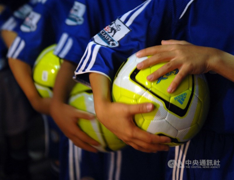 迎接2026年世界盃足球賽，製鞋廠看好賽事帶動周邊運動商機，更期盼2028年美國奧運能在未來幾年帶來備貨需求；面板廠同樣盼能搭上觀賞賽事的電視面板需求。圖為台灣小足球員抱著足球參加活動。（中央社檔案照片）