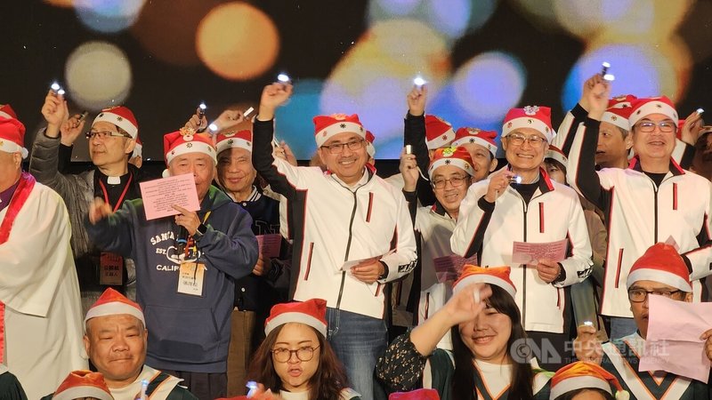 2025新北歡樂耶誕城系列活動「耶誕平安晚會」21日晚間登場，新北市長侯友宜（2排中）率市府團隊與百人詩班同台合唱報佳音。中央社記者王鴻國攝　114年12月21日
