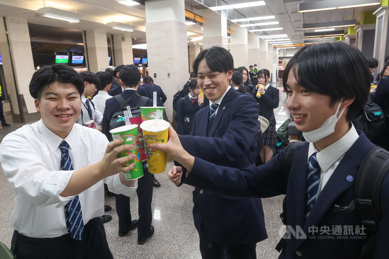 受文化總會邀請來台演出的日本東京農業大學第二高等學校吹奏樂部學生「翡翠騎士」,22日下午在台北松山機場搭機離台,學生在機場大啖珍珠奶茶。中央社記者吳家昇攝 114年12月22日