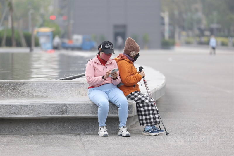 圖為台北市信義區民眾穿保暖衣服出門散步。（中央社檔案照片）