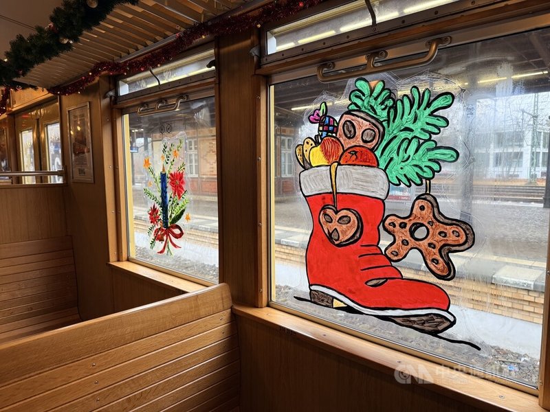 柏林懷舊耶誕列車車廂內,木質座椅與車窗貼紙保留威瑪共和到東德時期的城市快鐵樣貌。中央社記者林尚縈柏林攝 114年12月23日