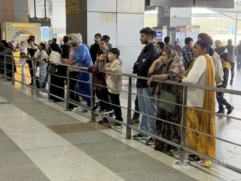 印度德里的英蒂拉．甘地國際機場（Indira Gandhi International Airport）因霧霾導致航班延誤，不少人焦急地趴在出口的圍欄，搜尋親友的身影。中央社記者李晉緯新德里攝　114年12月23日