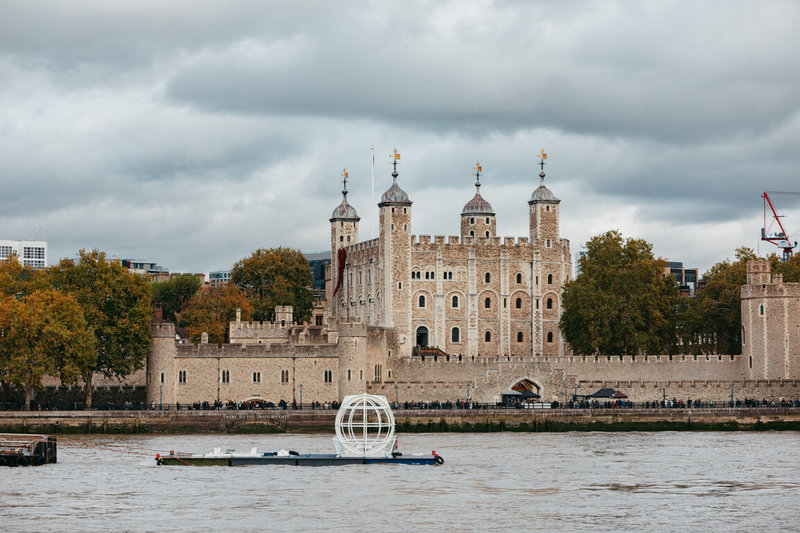 「倫敦眼」摩天輪預計至2029年執行座艙更新升級工程，期間將陸續有卸下的座艙沿著泰晤士河被運往工廠受檢施工。圖為被卸下的座艙途經倫敦另一知名地標「倫敦塔」古堡。（倫敦眼提供）中央社記者陳韻聿倫敦傳真　114年12月23日