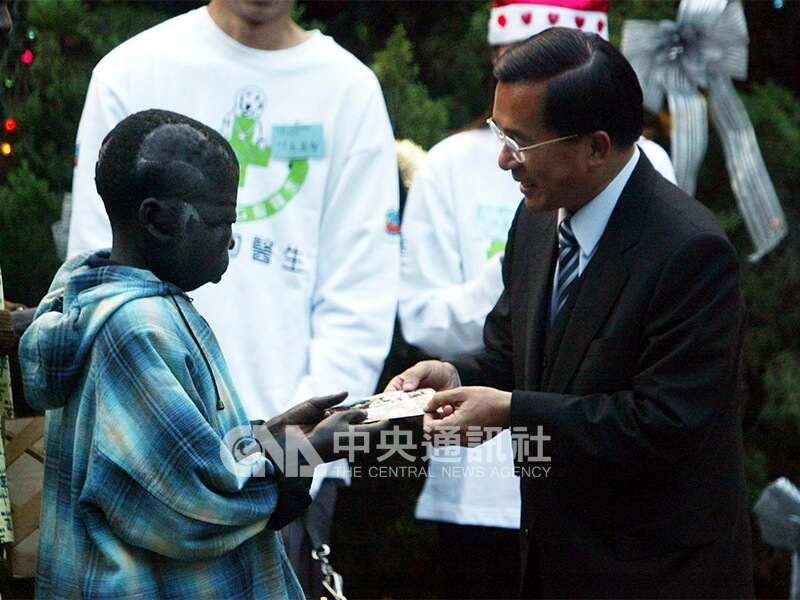 「非洲阿福」（左）在平安夜這天受總統陳水扁（右）之邀參加在總統官邸庭院舉行的耶誕節茶會。中央社記者吳繼昌攝　92年12月24日