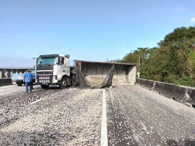 國道1號北上141公里苗栗銅鑼路段，24日發生砂石車翻覆事故，現場砂石散落，全線車道暫時封閉，後方車流嚴重回堵約10公里，截至下午3時尚在排除中。（警方提供）中央社記者管瑞平傳真　114年12月24日