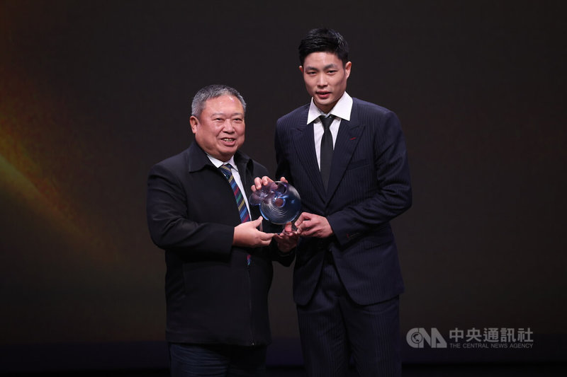 「台灣羽球一哥」周天成（右）24日從中華奧會主席林鴻道（左）手中接過114年體育運動精英獎最佳運動精神獎，他也替運動員發聲，希望未來可以增設獎金。中央社記者張新偉攝　114年12月24日