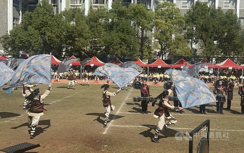 曉明女中管旗隊在校慶演出，搭配隆隆鼓聲，用力揮舞旗幟，在紅土操場上展現青春活力。中央社記者趙麗妍攝　114年12月24日