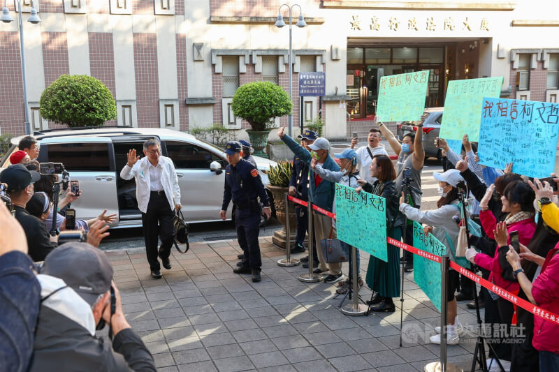 台北地方法院24日審理京華城等案，前台北市長柯文哲（白外套）出庭應訊，許多支持者到場舉牌加油打氣。中央社記者王騰毅攝  114年12月24日