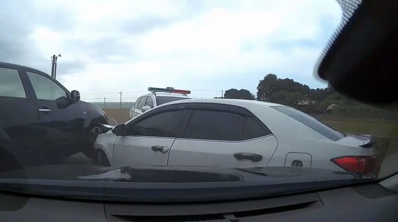 張姓通緝犯25日在雲林開車拒捕還企圖衝撞警車，員警對空鳴槍示警，張男最後還想騎機車逃逸，被多名員警壓倒制伏。圖為警方駕車夾擊張男車輛。（警方提供）中央社記者黃國芳傳真　114年12月25日
