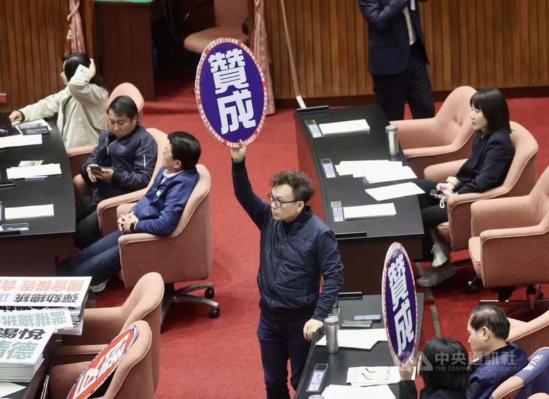 立法院會26日開會，國民黨團不滿憲法法庭判決憲法訴訟法修法違憲，提案譴責大法官謝銘洋、呂太郎、陳忠五、尤伯祥、蔡彩貞。在藍白人數優勢下，經表決將國民黨團所提譴責案逕付二讀，由國民黨團召集朝野黨團協商。圖為國民黨立委在議場內高舉贊成手舉牌。中央社記者張皓安攝　114年12月26日