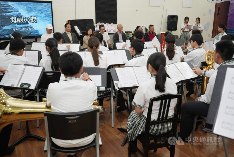 屏東縣大同高中管樂班學生26日歡迎日本學者井上裕太（後左4）等人來訪，現場演奏並合唱由井上裕太創作的歌曲「海峽之淚」，以音樂串起台日友誼。中央社記者黃郁菁攝　114年12月26日