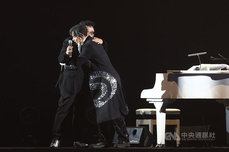 歌手李聖傑（右）出道26年首度站上台北小巨蛋舉辦演唱會，26日晚間在台上擁抱音樂路上的重要貴人鮑比達（左），感謝他擔任這次演唱會演出嘉賓。中央社記者王騰毅攝  114年12月26日