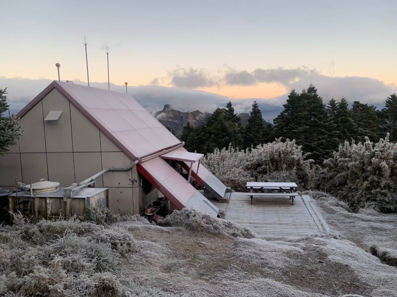 雪山山脈地區26日清晨降下白雪，積雪厚度達約4公分，讓登山的遊客相當驚喜。圖為武陵四秀桃山山屋。（布農卡里布灣企業社黃培軒提供）中央社記者魯鋼駿傳真　114年12月26日