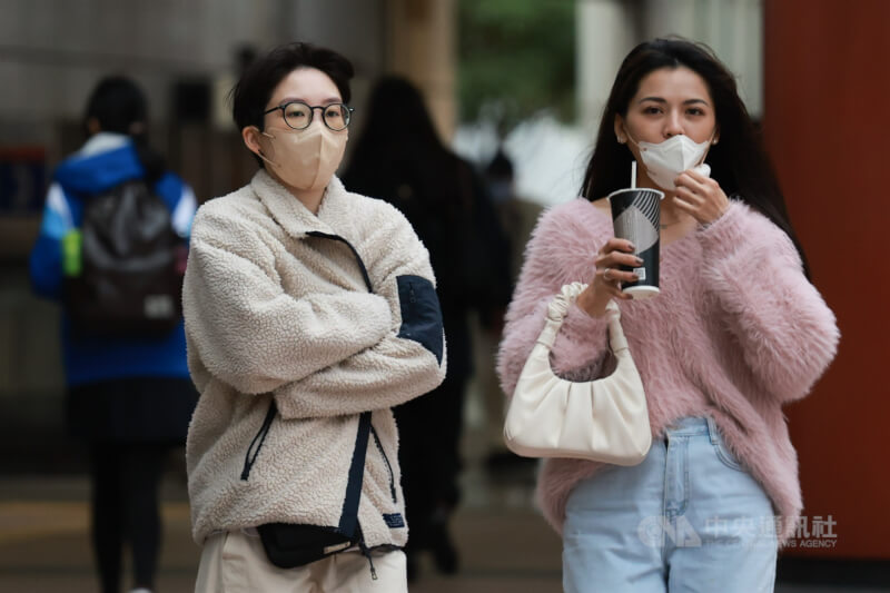 圖為新北市板橋區外出民眾拉緊外套保暖。（中央社檔案照片）