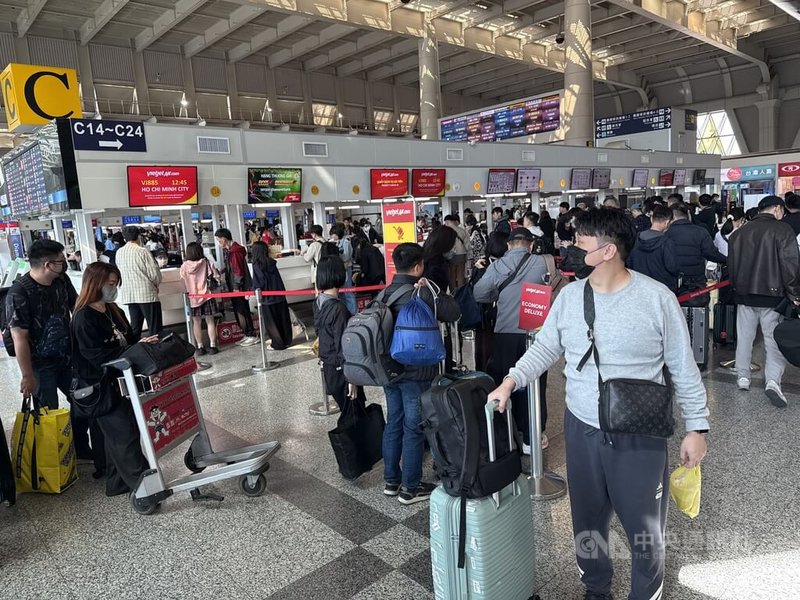 中共發動圍台軍演，民航局30日表示，經航管單位透過替代航路等各種方式引導航機，國際線尚無航班取消，另有部分過境航班取消飛越。圖為高雄小港國際機場旅客在櫃台前排隊等待辦理出境手續。中央社記者董俊志攝　114年12月30日