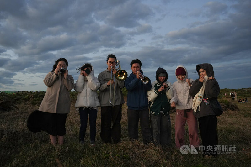 中山大學音樂系學生1日凌晨從高雄驅車，前往龍磐公園看日出。其中黃帛彥（左4）及邱揚珽（左3）各以小號及長號，演奏You Raise Me Up。中央社記者黃郁菁攝　115年1月1日