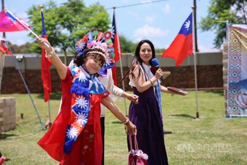 南非僑界舉行元旦升旗典禮，一位身穿自製國旗裝、頭戴歌仔戲冠、揮舞國旗跳舞的女士（左）獲得「最佳造型服裝獎」。中央社記者李依璇約翰尼斯堡攝　115年1月2日